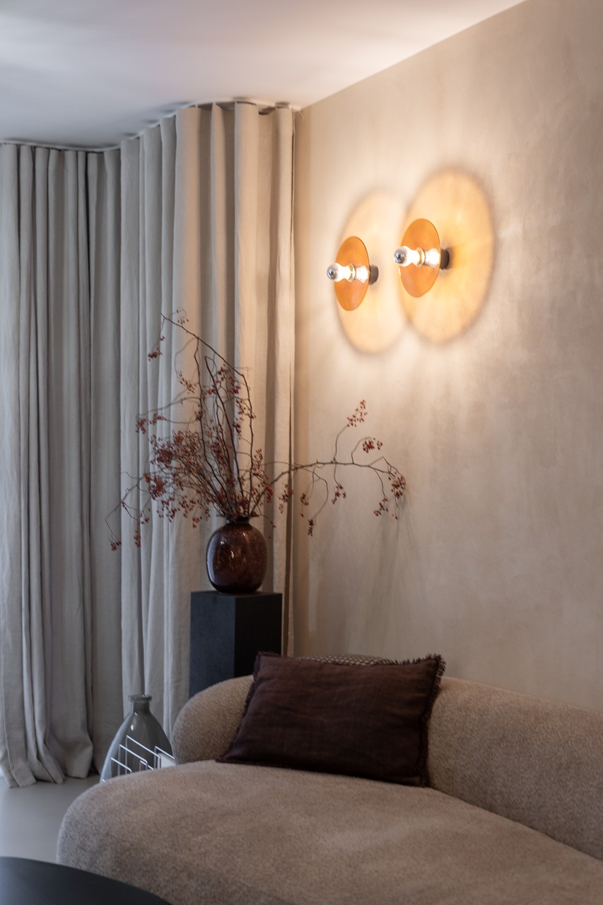 Przytulne wnętrze z designerską sofą i stylowym oświetleniem.
