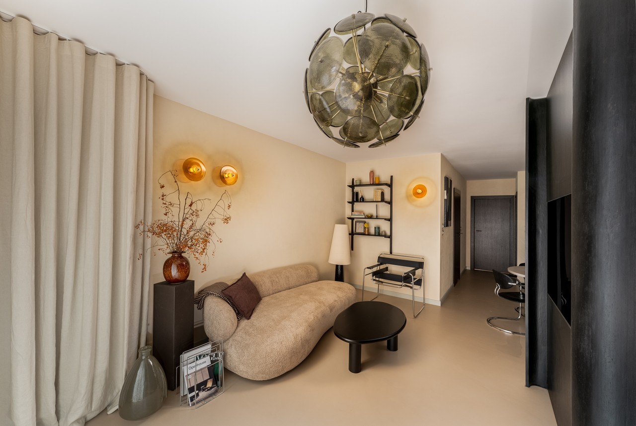 Stylowy salon z designerską sofą i oryginalnym oświetleniem.