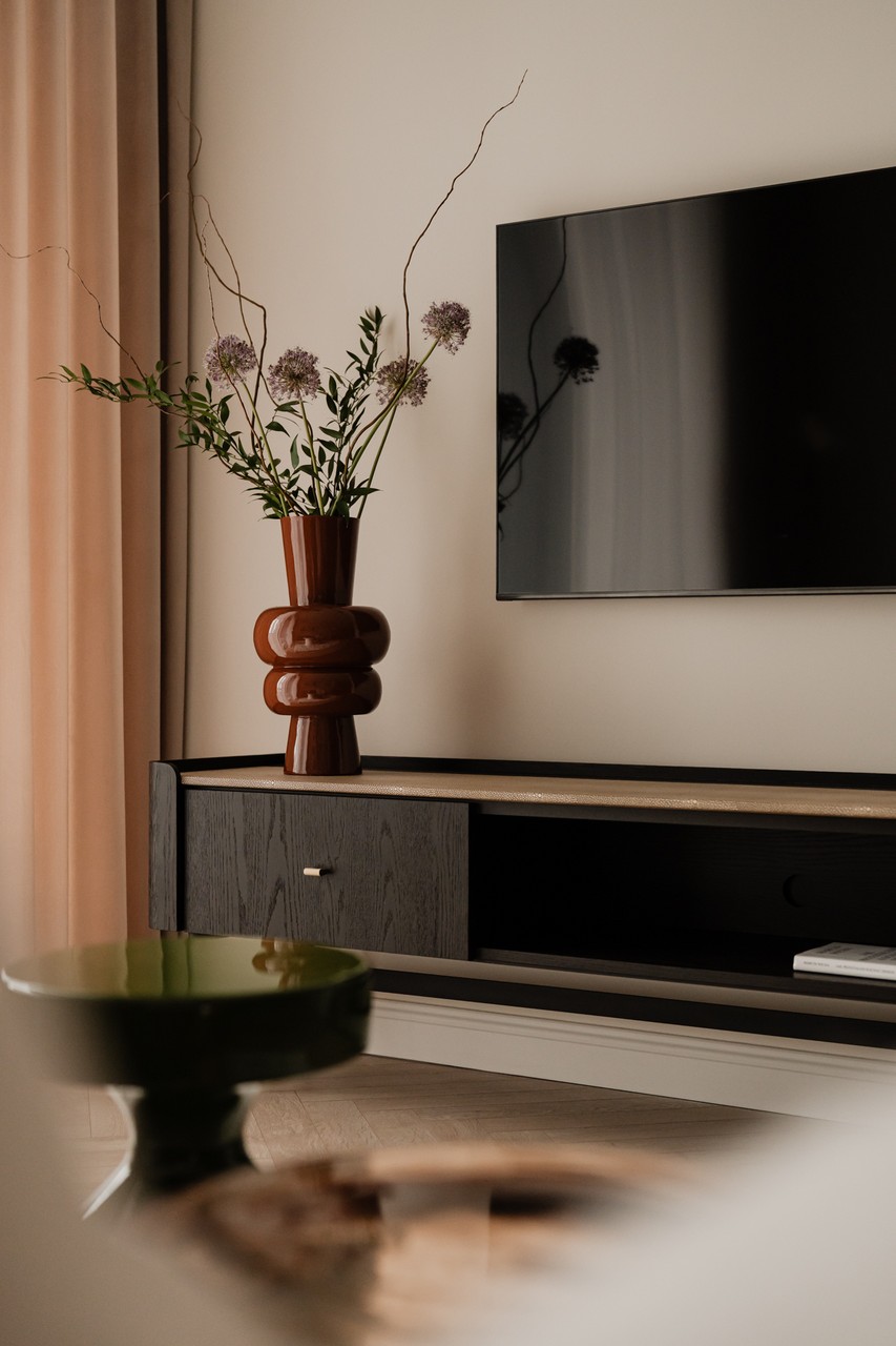 Telewizor z drewnianą szafką i designerskim wazonem