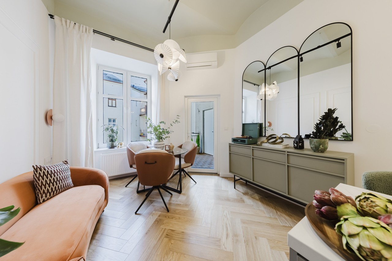 Stylowy salon z drewnianą podłogą i eleganckimi dodatkami.