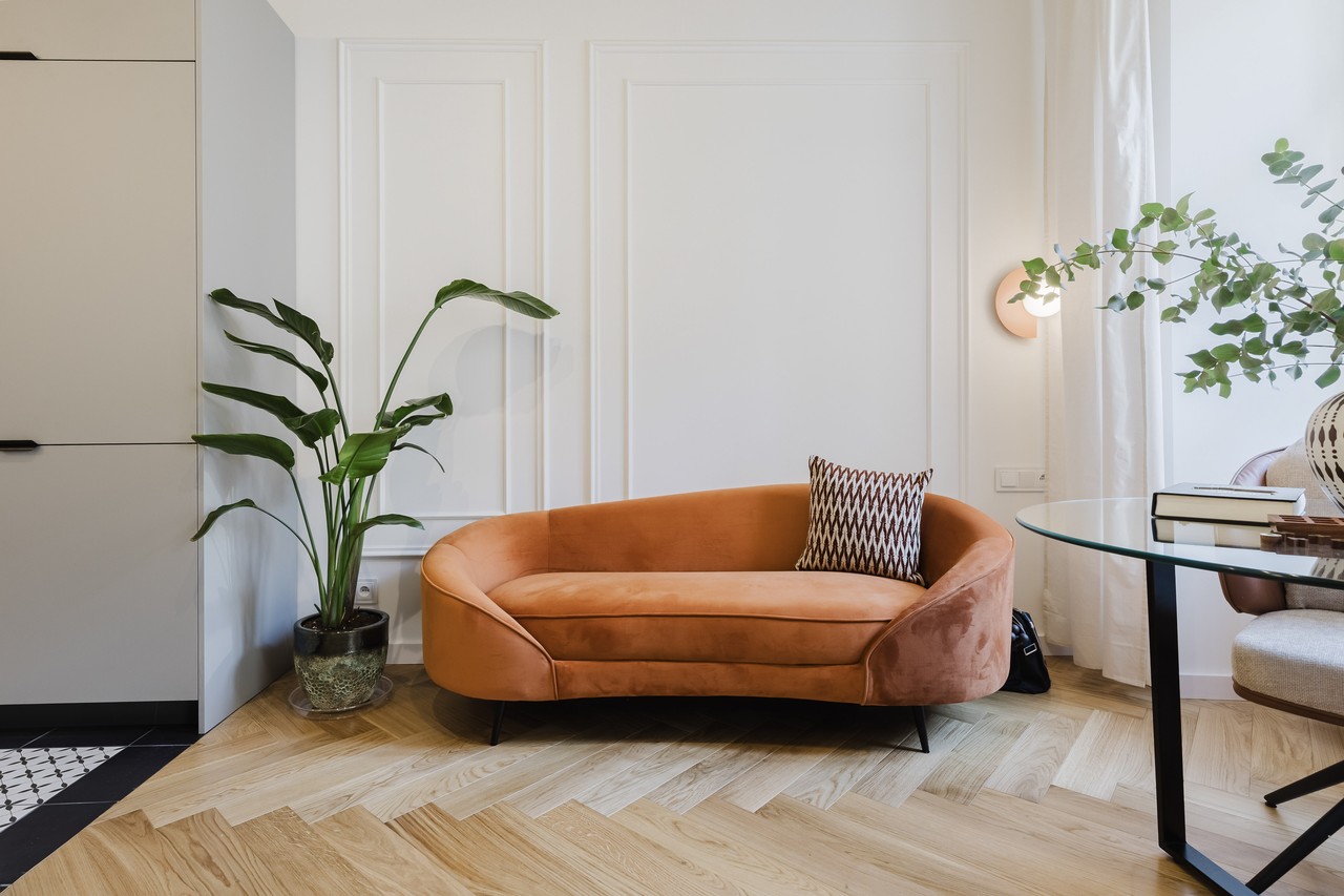 Przytulna sofa retro w stylowym salonie z rośliną i stolikiem.