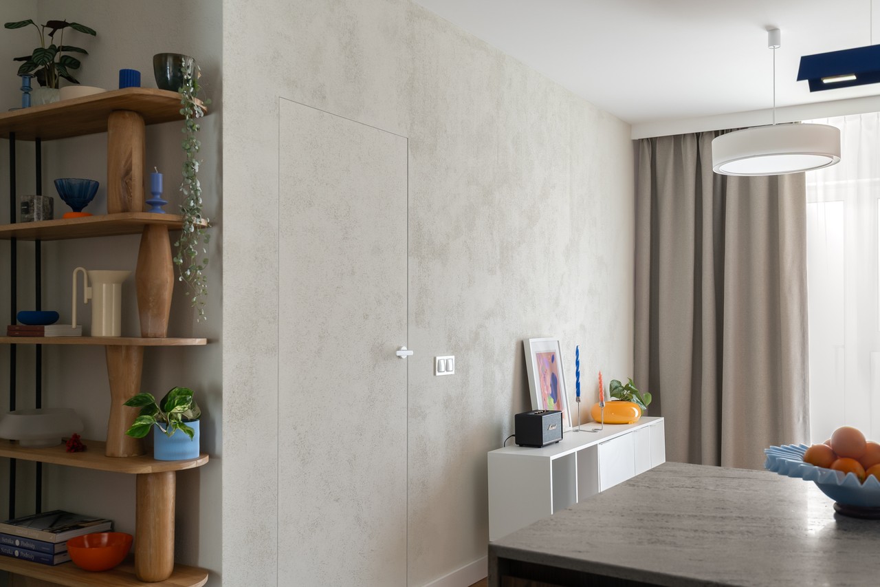 Stylowy salon z designerskimi półkami i nowoczesnym oświetleniem.