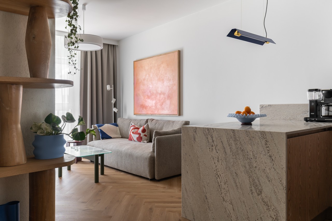 Nowoczesny salon z beżową sofą i sztuką na ścianie.
