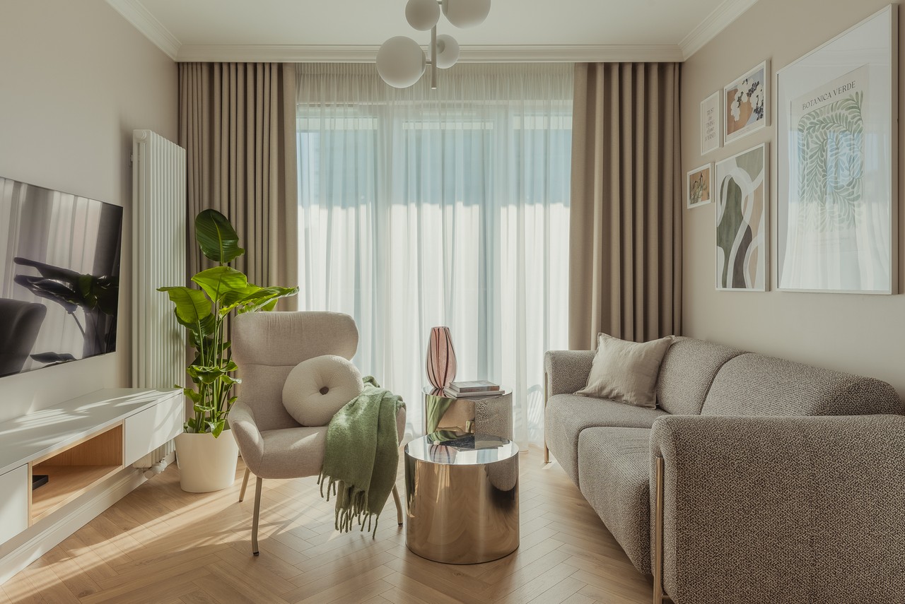 Przytulny salon z designerskimi meblami i sztuką na ścianach.