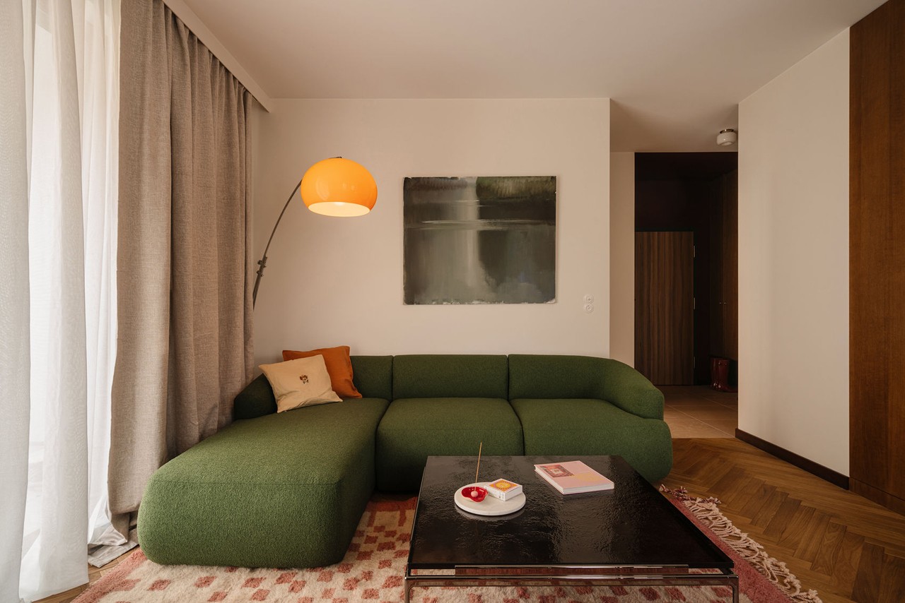 Zielona sofa i lampa w przytulnym salonie retro.