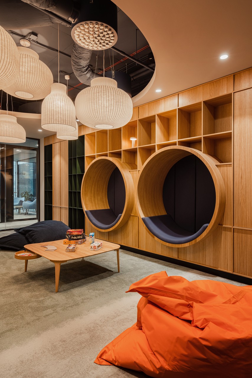 Przytulna przestrzeń z designerskimi siedziskami i nowoczesnym oświetleniem.