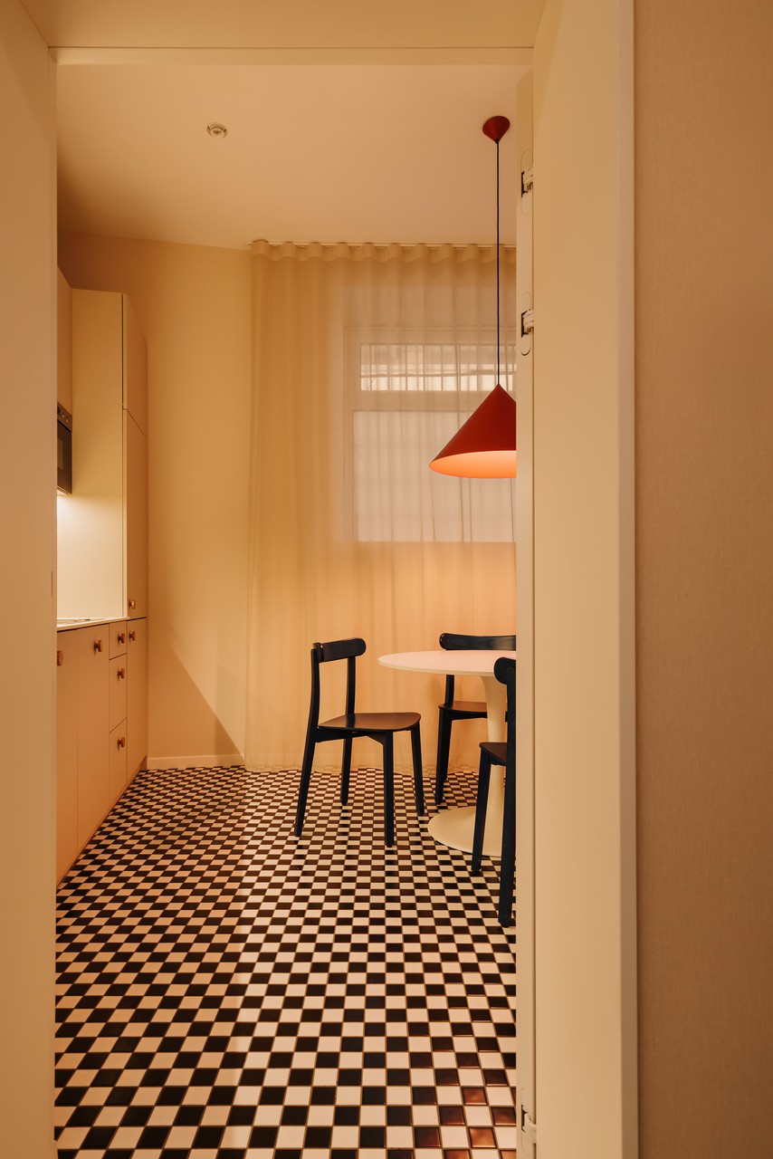 Kuchnia retro z szachownicą i designerską lampą.