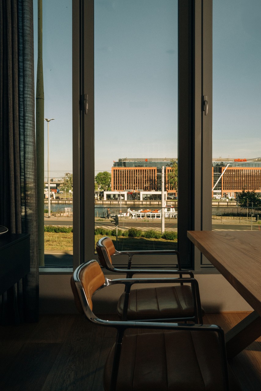 Wnętrze biura z widokiem na nowoczesną architekturę za oknem.