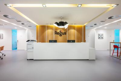 Recepcja z nowoczesnym drewnianym wykończeniem i elegancką lampą.
