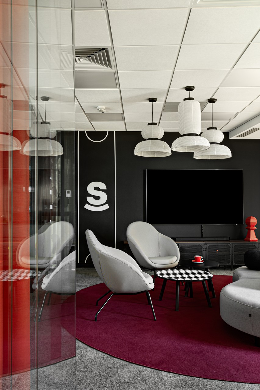 Nowoczesne biuro z designerskimi fotelami i eleganckimi lampami.