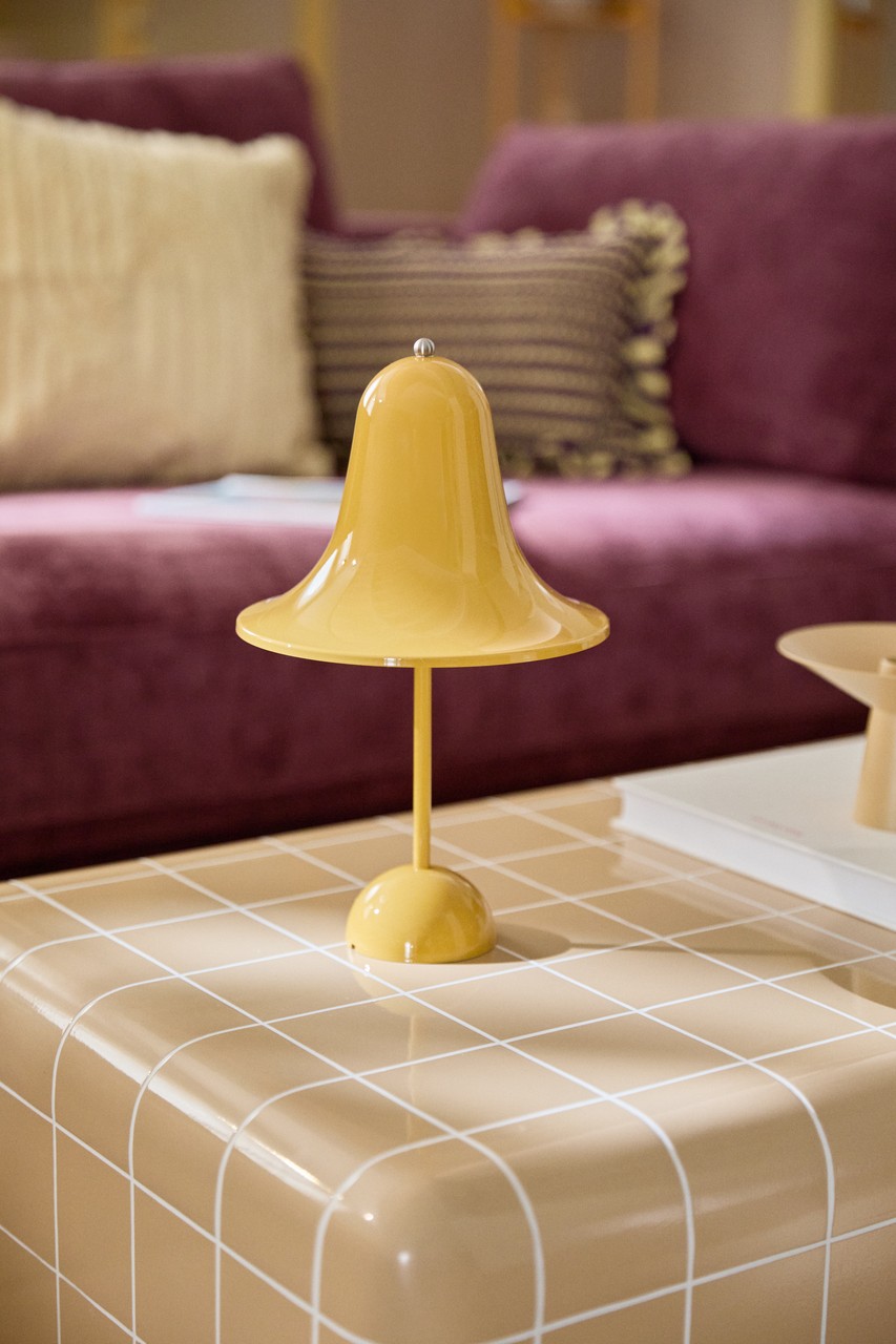 Żółta lampa stołowa na kaflowym stoliku, modny dodatek do salonu.
