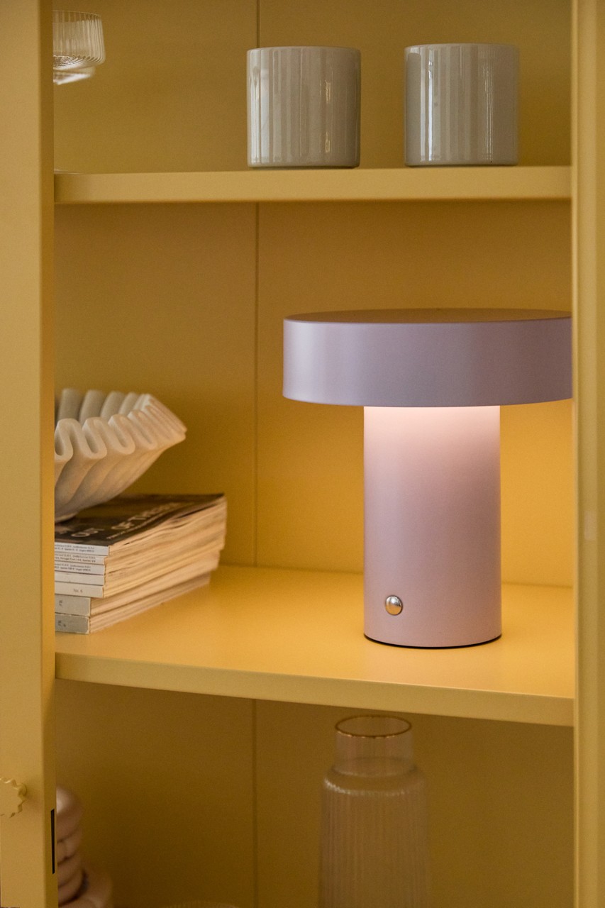 Półka z designerską lampą i eleganckimi dekoracjami.