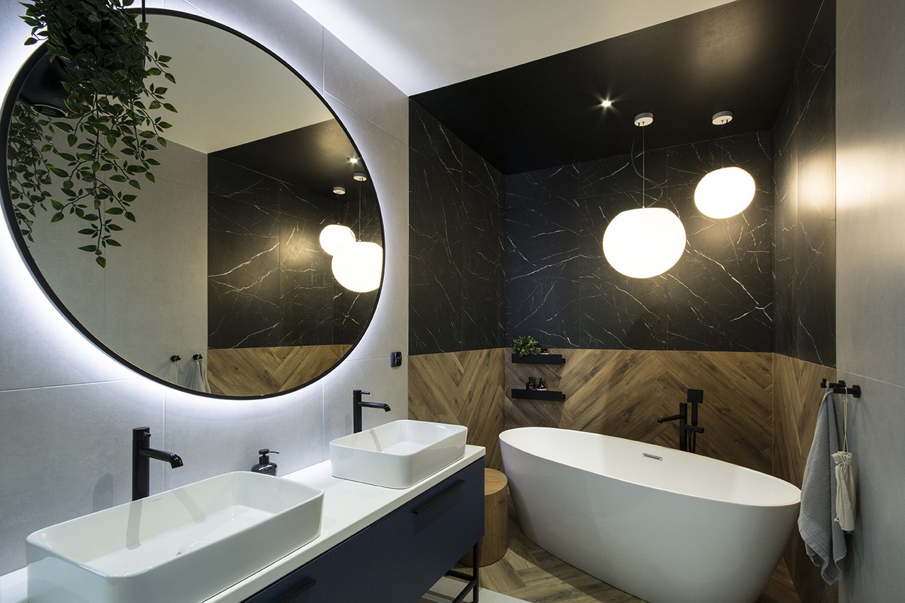 Nowoczesna łazienka z owalną wanną i designerskimi lampami.
