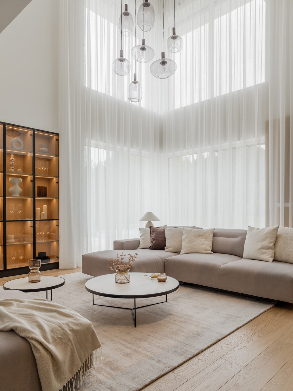 Elegancki salon: nowoczesna kanapa, stoliki i designerskie oświetlenie.