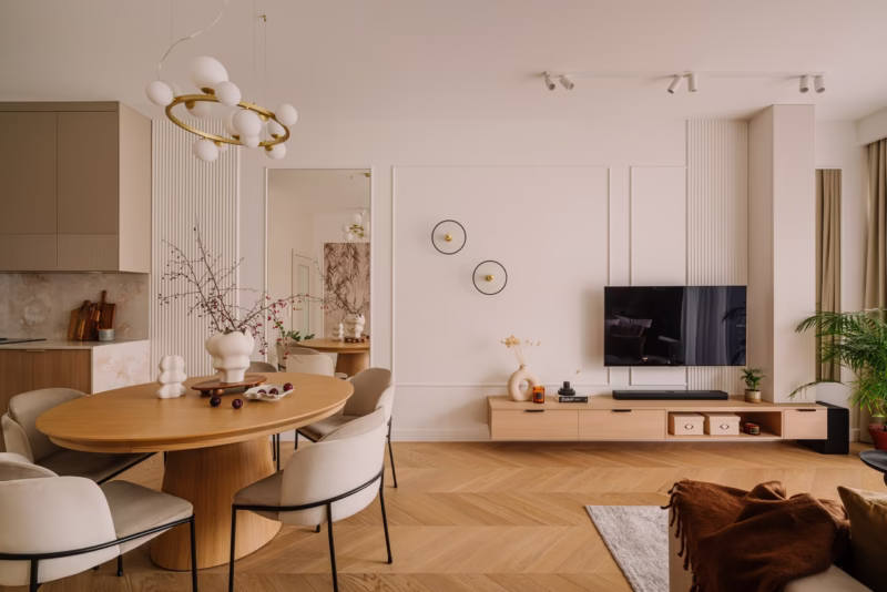 Nowoczesny salon z eleganckim stołem i drewnianą podłogą.