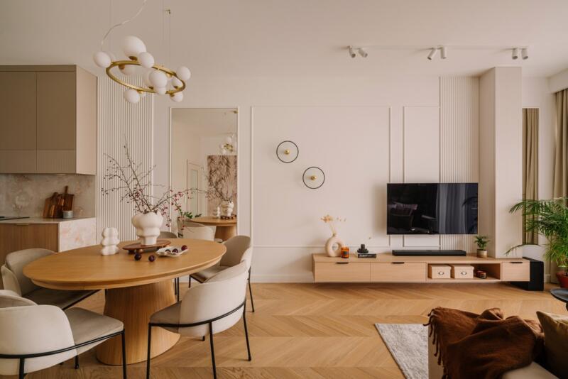 Nowoczesny salon z eleganckim stołem i drewnianą podłogą.