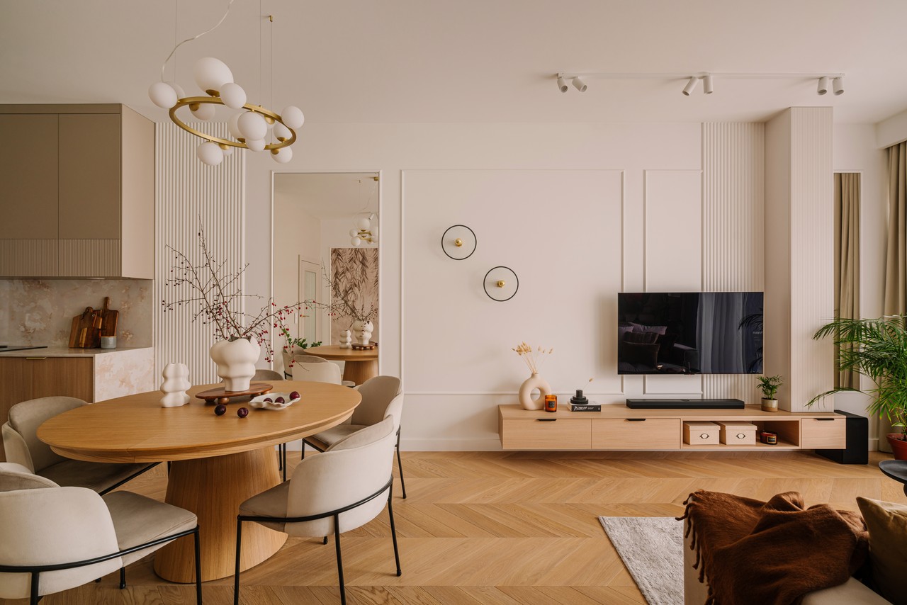 Nowoczesny salon z eleganckim stołem i drewnianą podłogą.