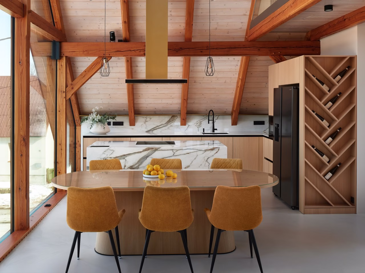 Nowoczesna kuchnia z drewnianymi belkami i marmurową wyspą.