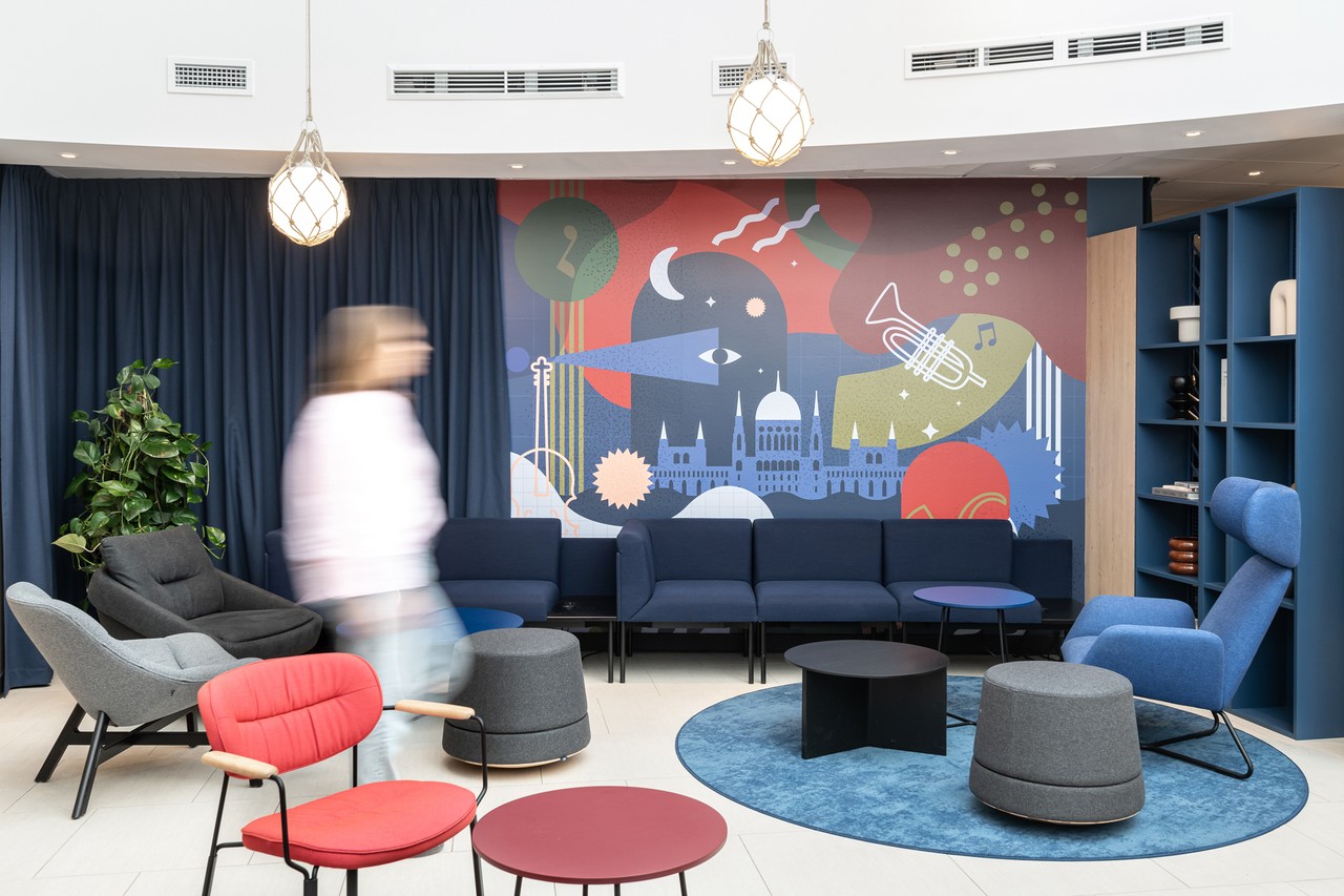 Nowoczesny salon z kolorową grafiką i designerskimi meblami.