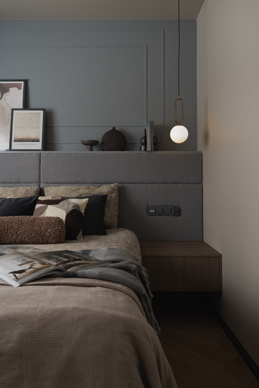A modern bedroom with a designer lamp and cozy pillows.