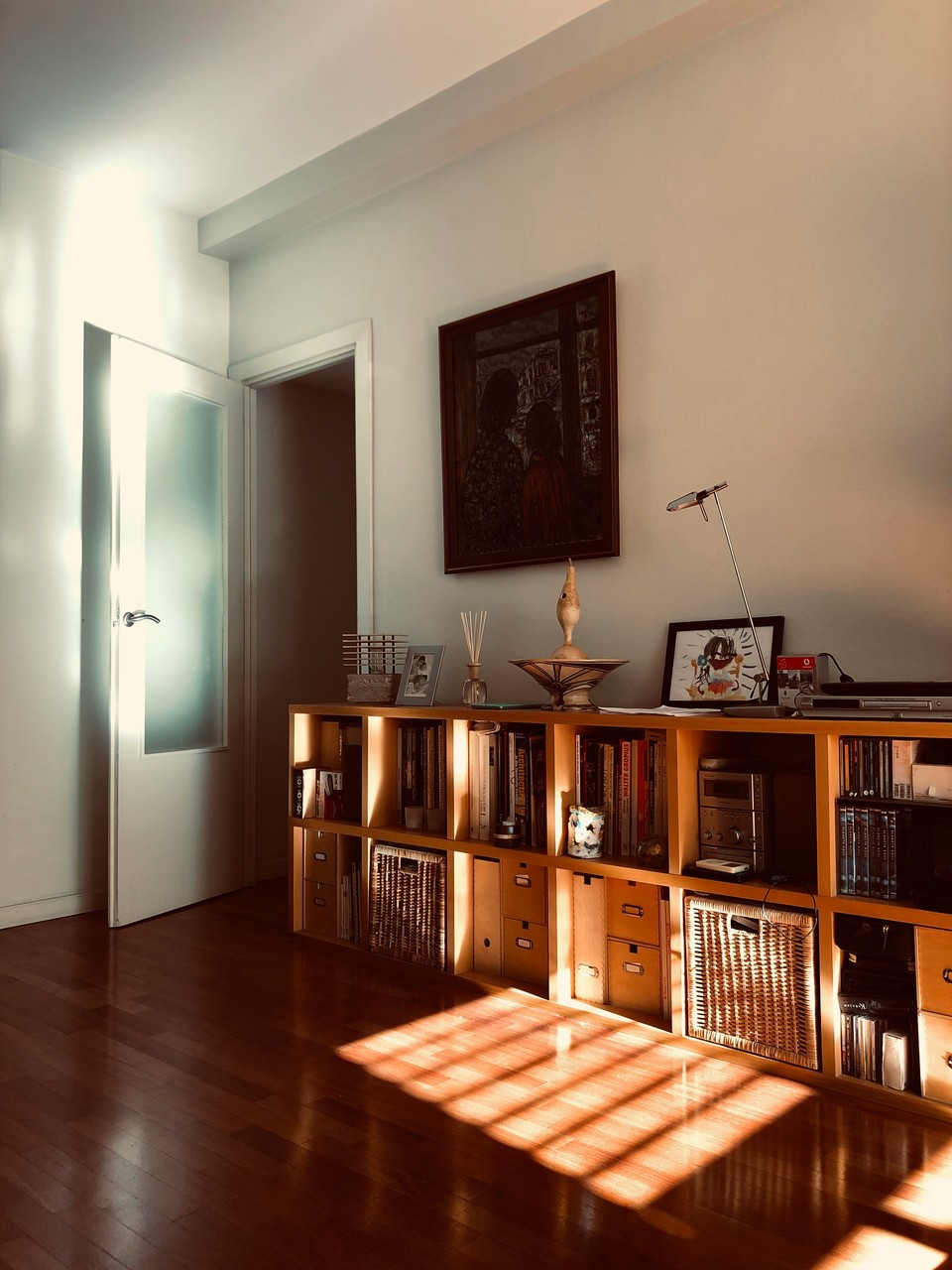 Przytulny salon z półkami w stylu skandynawskim i drewnianą podłogą.