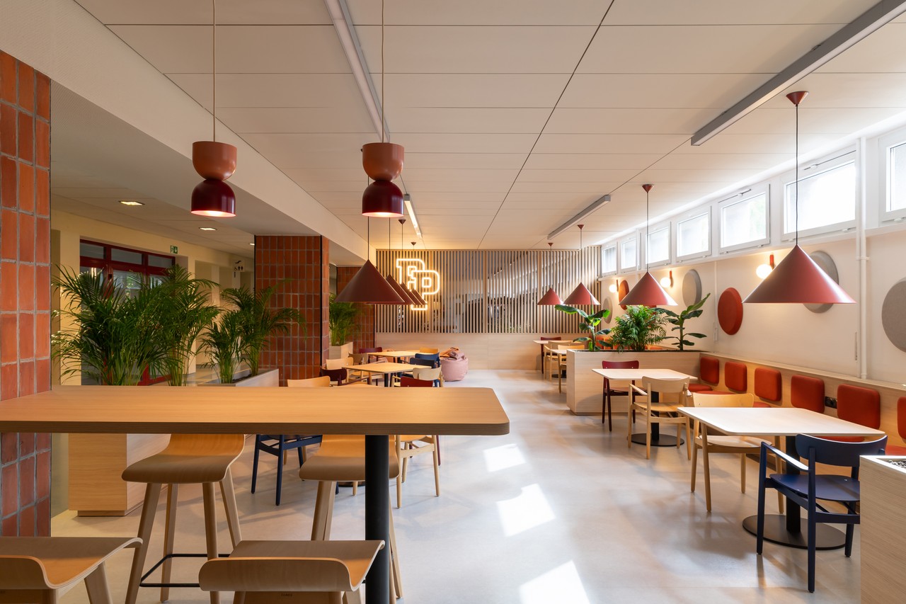 Nowoczesne wnętrze z drewnianymi stołami i designerskimi lampami.