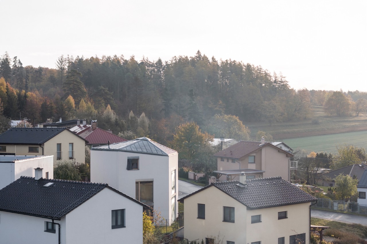 Osiedle domków w jesiennej, malowniczej scenerii lasu i pól.