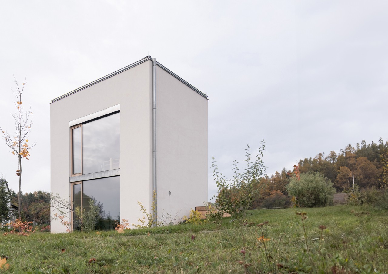 Minimalistyczny dom w otoczeniu natury i nowoczesnej architektury.