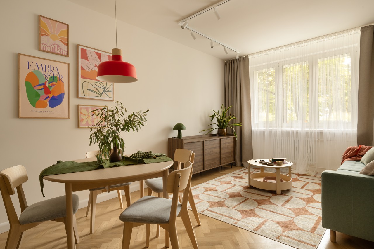 Przytulny salon z designerskimi plakatami i nowoczesnymi meblami.