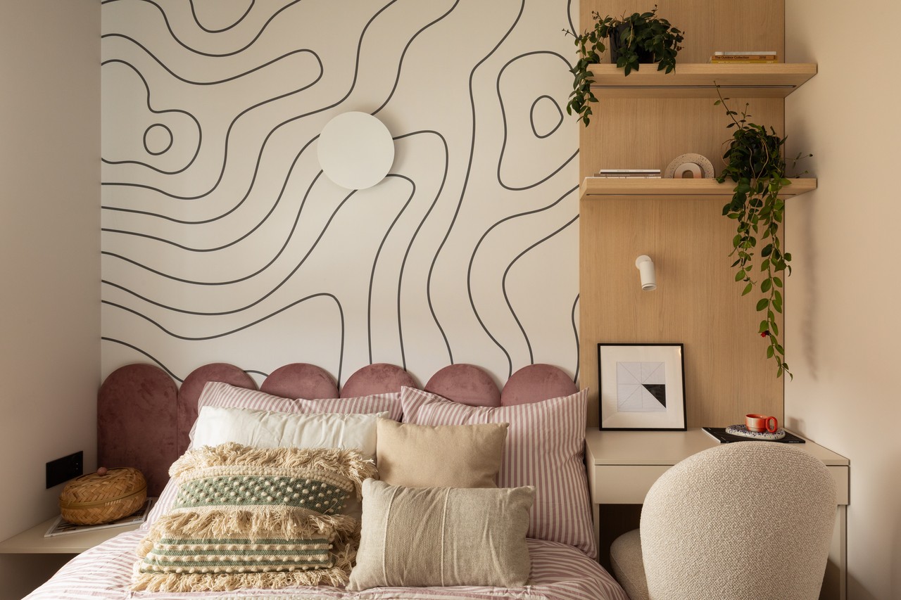 Przytulna sypialnia z designerską ścianą i eleganckimi poduszkami.