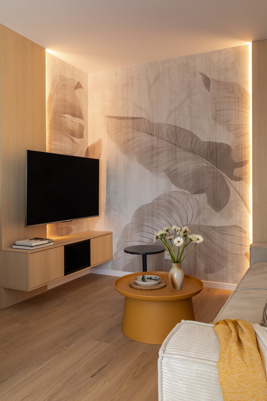 Elegancki salon z dużymi liśćmi na ścianie i nowoczesnym stolikiem.