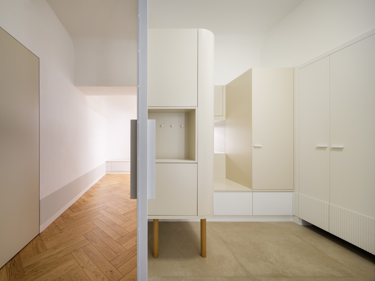 Minimalistyczne wnętrze z jasnymi meblami i drewnianą podłogą.