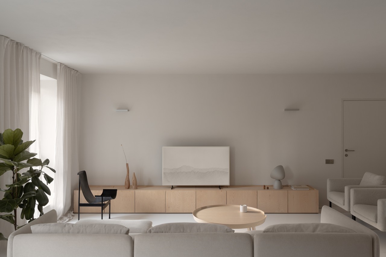 Przytulny salon w stylu minimalistycznym, jasne meble i sofa.