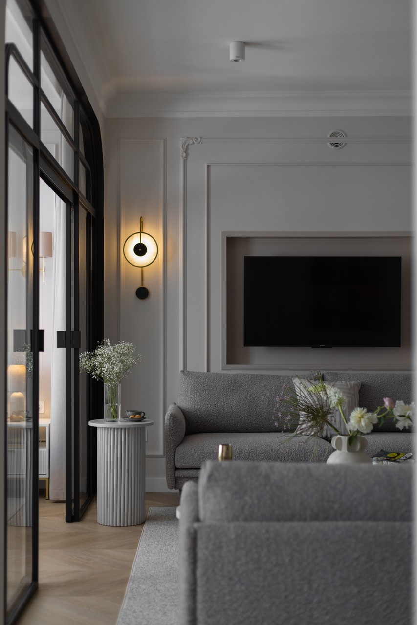Elegancki salon z szarymi meblami i stylowym oświetleniem.