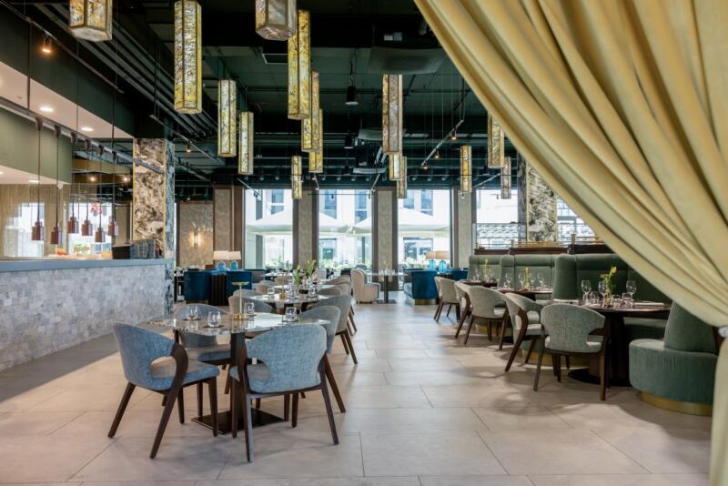 Elegancka restauracja z nowoczesnym oświetleniem i stylowymi krzesłami.
