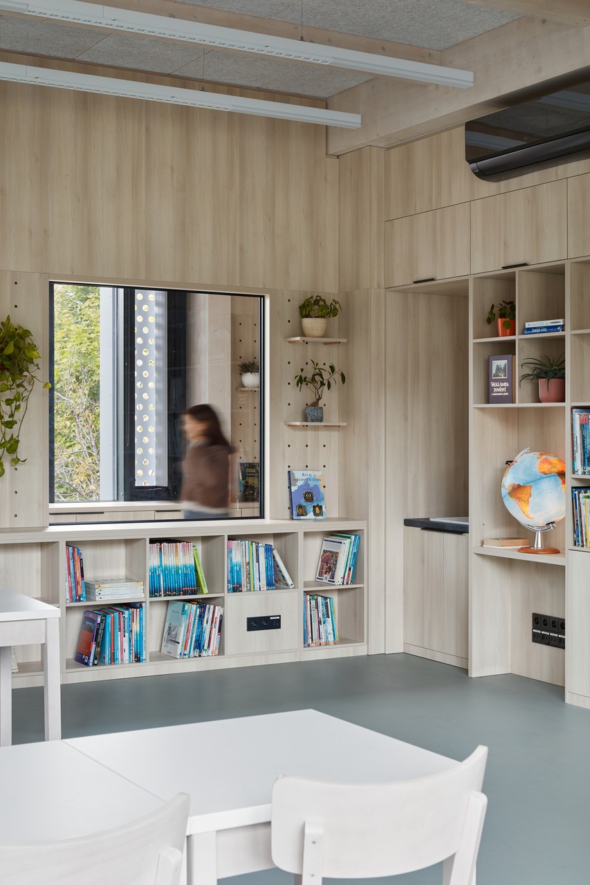 Nowoczesna przestrzeń biblioteczna z drewnianymi regałami.