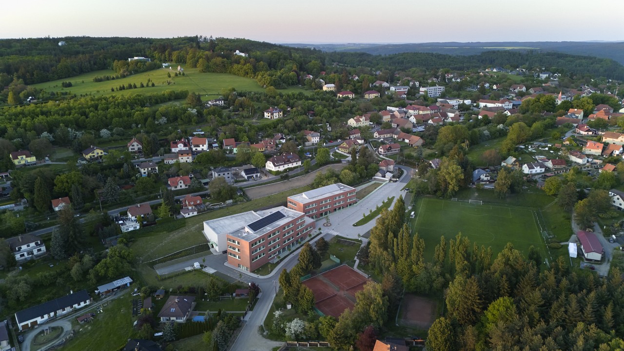 Widok z lotu ptaka na zieloną okolicę z nowoczesnym budynkiem.