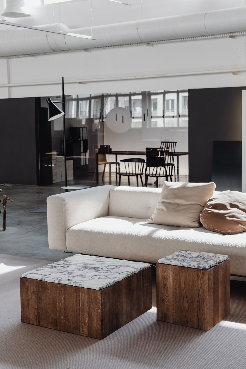 Nowoczesny salon z sofą i designerskimi stolikami.