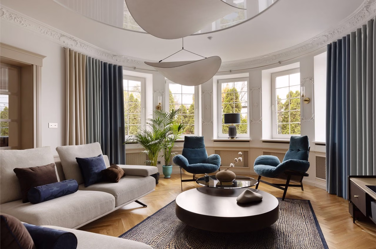 Przestronny salon z eleganckimi sofami i designerskim oświetleniem.