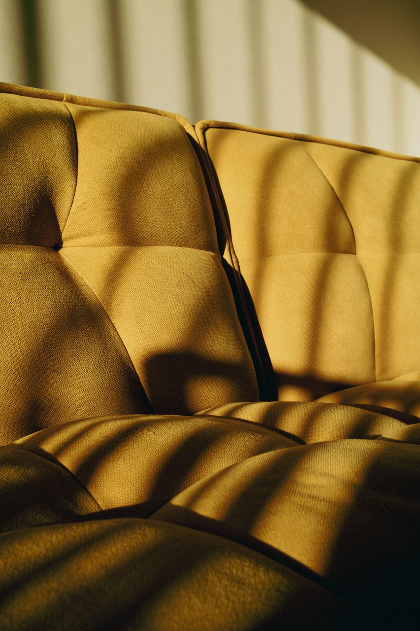 Złota sofa w promieniach słońca, stylowa elegancja wnętrza.