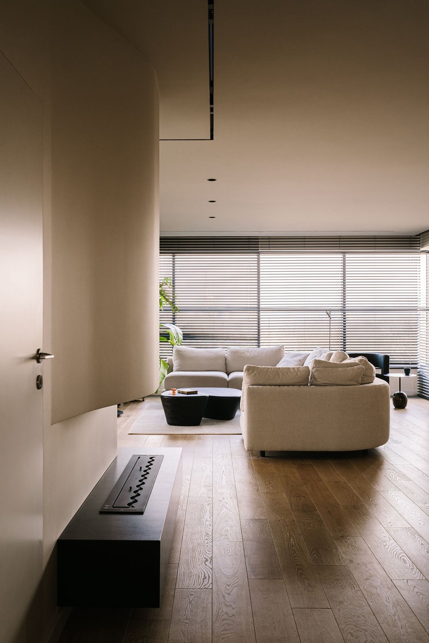 Nowoczesny salon z jasną sofą i dużymi oknami. Decyzja minimalistyczna.