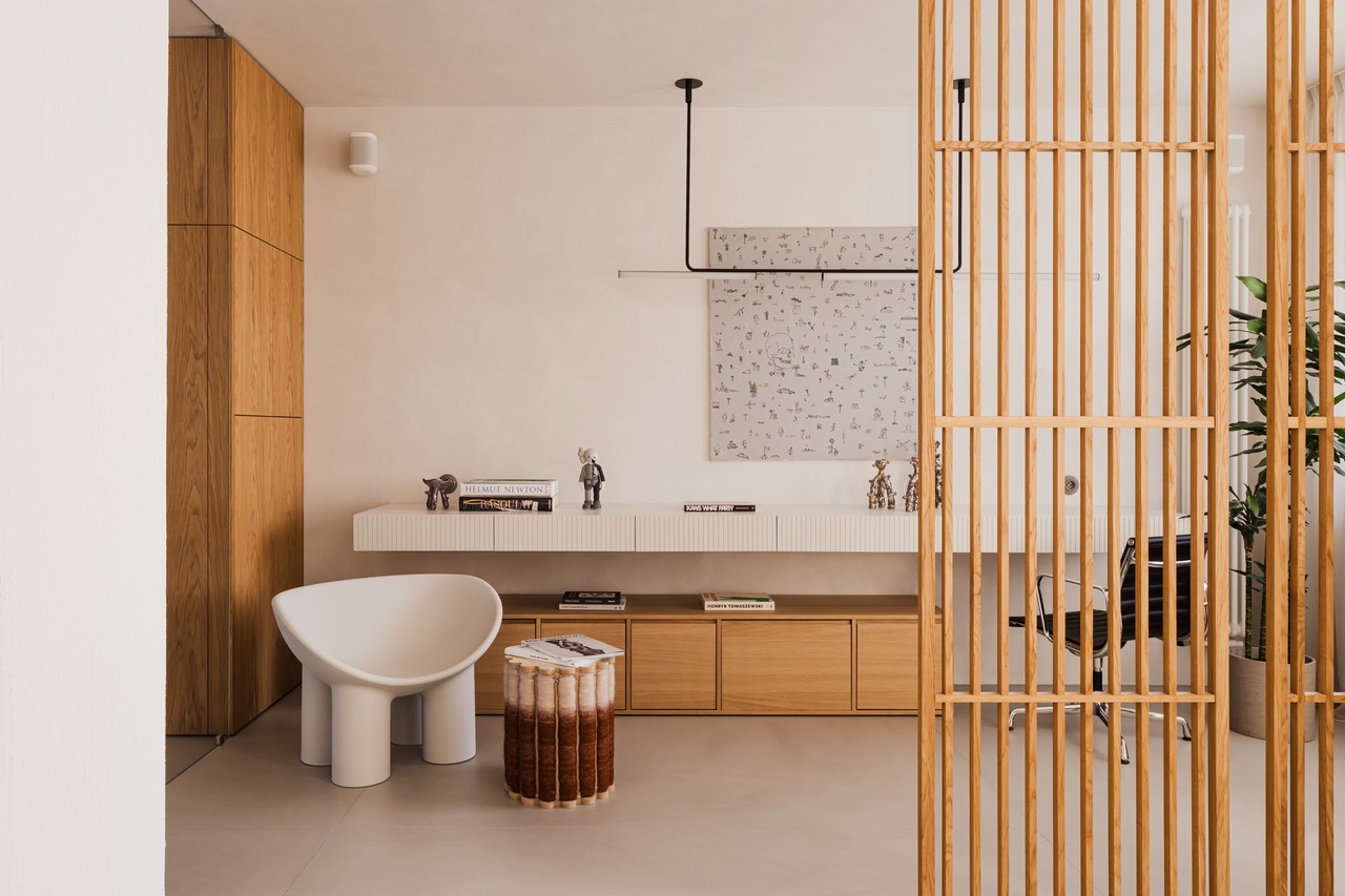 Minimalistyczne biuro z designerskimi meblami i drewnianą przegrodą.