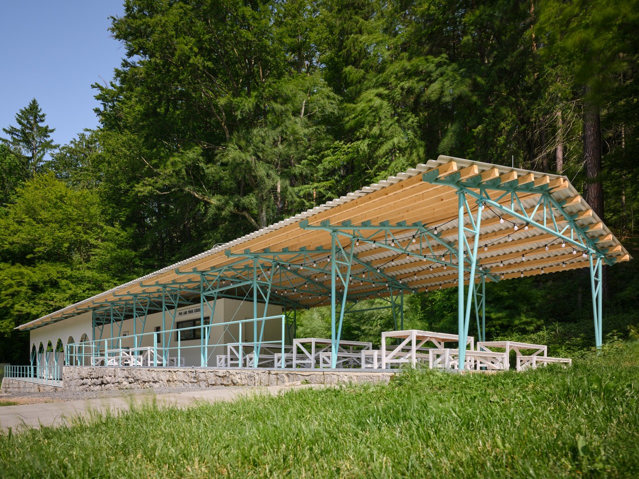 Struktura z drewna i metalu wśród zieleni, architektura otwarta.