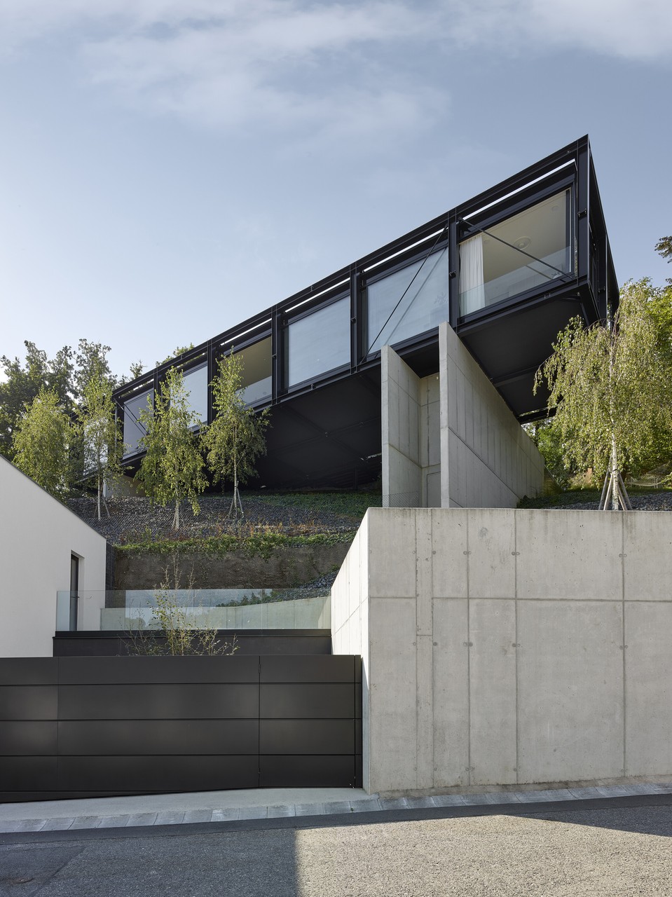 Nowoczesna architektura na wzgórzu, dom z czarnego metalu i szkła.