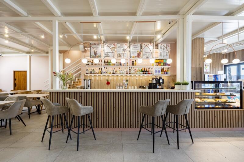 Stylowy bar z eleganckimi hokerami i nowoczesnym oświetleniem.