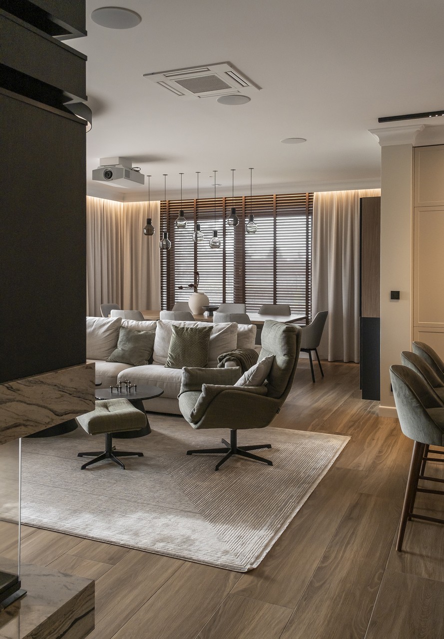 Elegancki salon z nowoczesnym oświetleniem i wygodnymi fotelami.