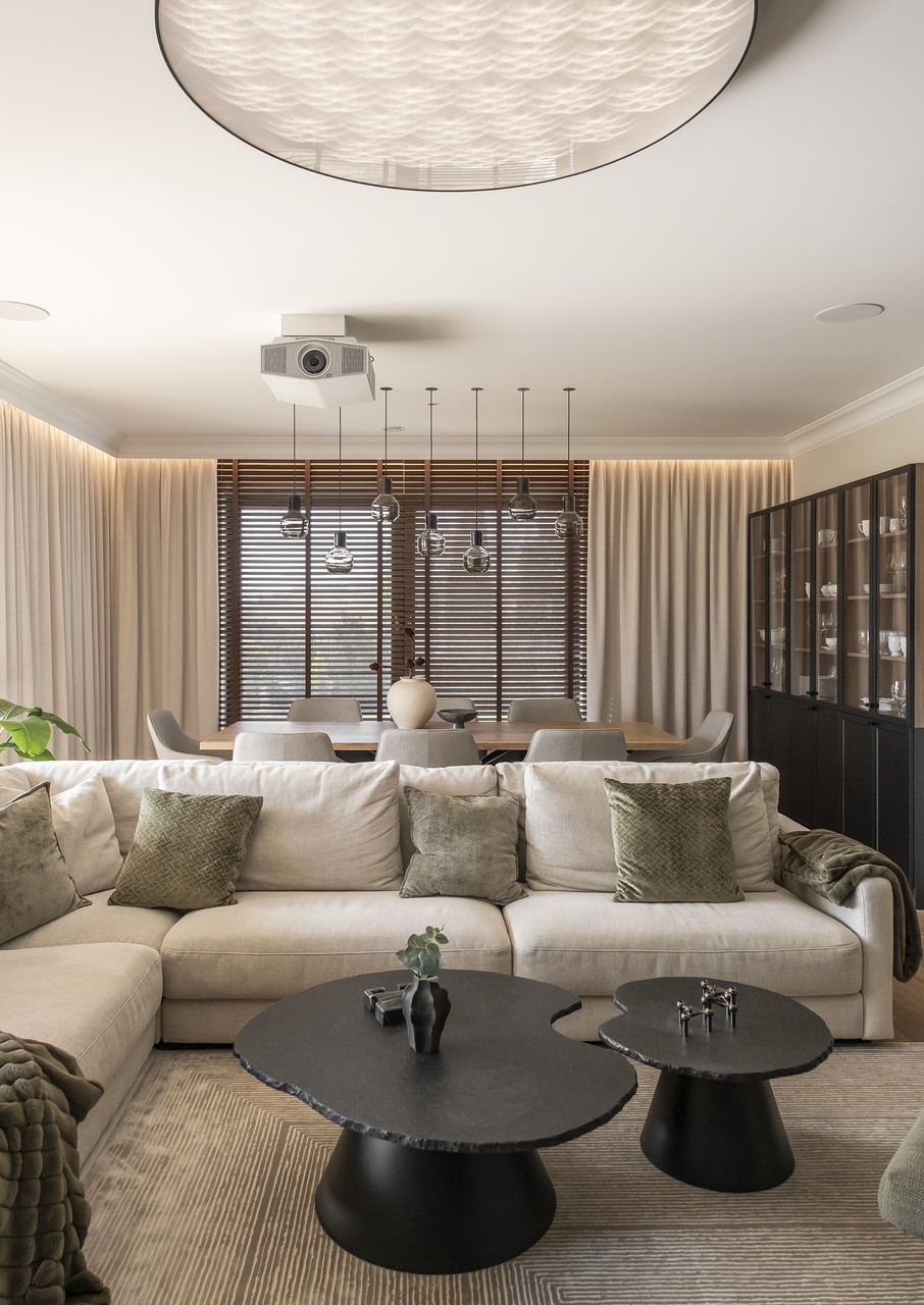 Elegancki salon z designerskimi stolikami i nowoczesnym oświetleniem.