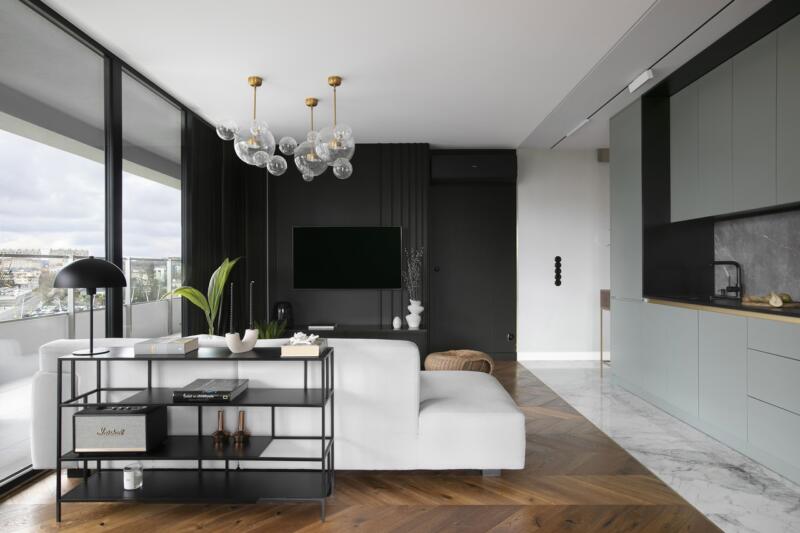 Modern living room with large windows, elegant sofa, designer lighting.