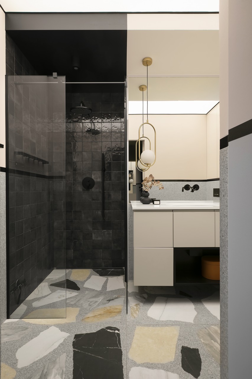Elegant bathroom with stone mosaic and modern lighting.