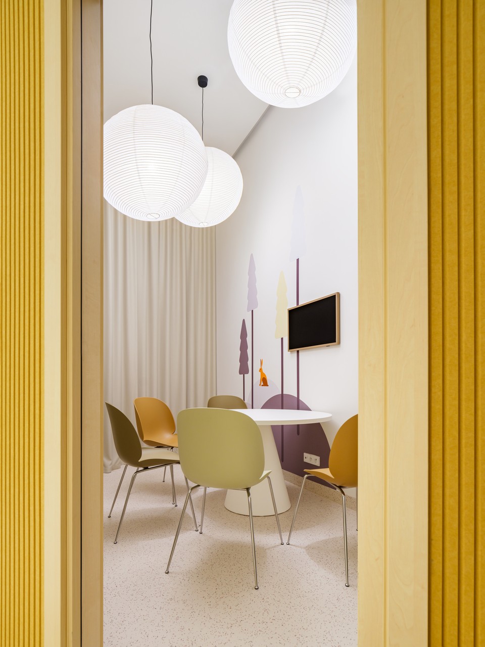 Przytulna sala z designerskimi krzesłami i lampami.